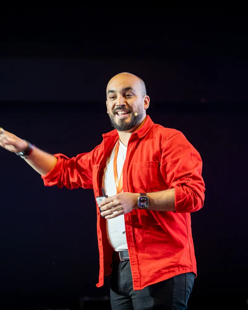 Rodrigo Rojo explicando en el escenario, con camisa roja